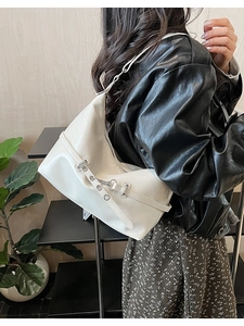 Detail view of cream vintage hobo bag featuring silver metal buckle and leather texture