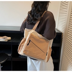 Detail of canvas tote bag with contrast colors, side drawstring pocket and shoulder strap