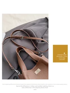 Detail of brown litchi pattern leather bucket bag with silver twist lock on grey blazer