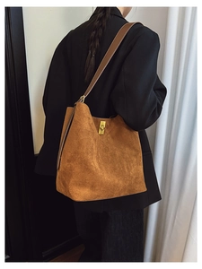 Detailed macro view of the brown suede hobo bag with a luxury gold metal twist lock closure