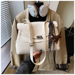 Detail of off-white lychee leather tote with silver twist lock and dachshund charm