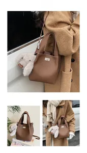 Close-up of brown pebbled leather bucket bag featuring a silver twist lock and plush bunny charm
