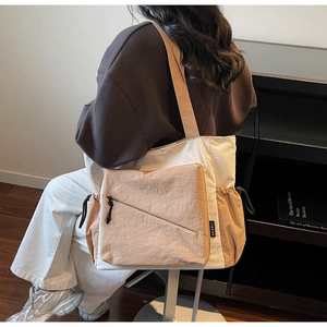 Detail of canvas tote bag with front zipper pocket and drawstring side compartments
