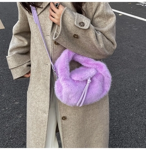 Détail d'un sac à main en fausse fourrure violette avec garniture à pompons