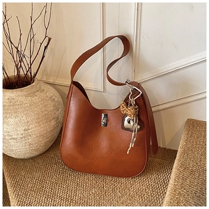 Detail of vintage brown hobo bag with silver turn-lock and leopard print bow charm