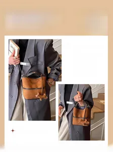 Detail view of brown matte bucket bag with contrast trim and cute plush dog charm