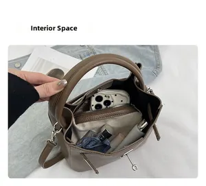 Interior view of brown lychee leather bucket bag showing storage for phone and cosmetics