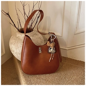 Close-up of retro brown hobo bag with silver lock and leopard bow heart charm
