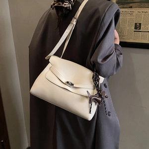 Detail of creamy white pebble leather tote bag with silver twist lock and dog charm