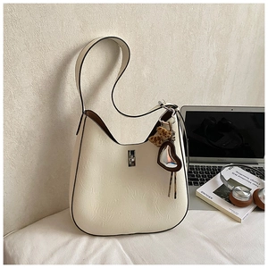 Detail of cream hobo bag with natural leather texture and leopard print heart charm