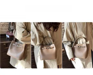 Detail of brown lychee leather handbag featuring a single handle and detachable strap