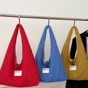 Détail du sac cabas en peluche avec fermoir bascule et doublure à carreaux