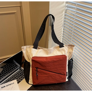 Detail of canvas tote bag showing side drawstring pocket and woven brand label