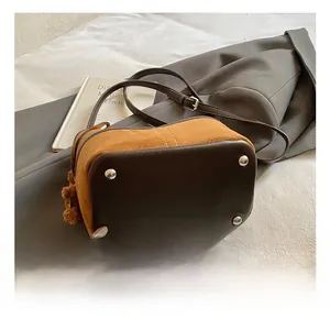 Detail view of the vintage bucket bag base with protective silver studs and leather texture
