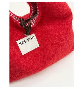 Détail du sac cabas en peluche rouge avec bouton en corne et doublure à carreaux
