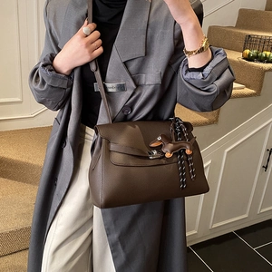 Close-up of brown lychee leather tote bag with silver twist lock and dachshund charm