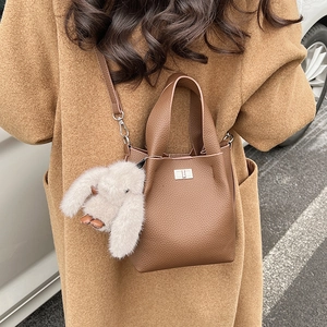 Brown textured leather bucket bag with silver twist lock and cute plush rabbit charm
