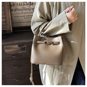 Detail of lychee textured leather bucket bag with metal twist lock and vintage buckle