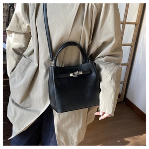 Black lychee leather bucket bag with silver buckle worn with a khaki overcoat