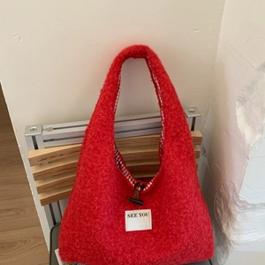 Détail du sac cabas rouge en peluche avec boucle en corne et doublure vichy