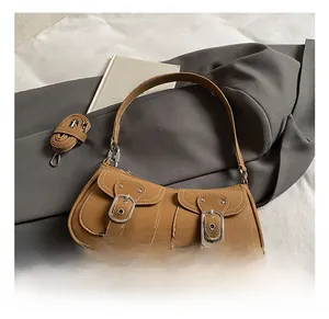 Close-up of vintage brown underarm bag featuring double pockets and silver metal buckles