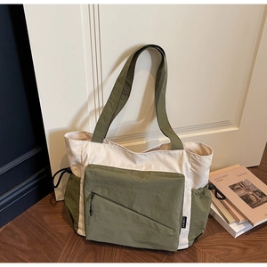 Detail view of canvas tote bag with olive green and beige patchwork and drawstring side pocket