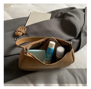 Internal storage detail of brown vintage crescent shoulder bag showing everyday essentials