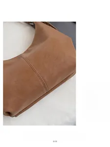 Detail view of large capacity tote bag featuring caramel brown lychee leather and stitching