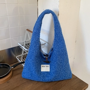 Détail du cabas bleu en polaire peluche avec bouton en corne et patch en tissu