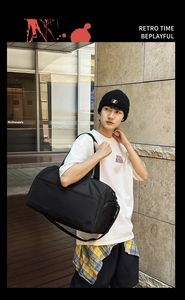 Close-up of black waterproof travel bag with adjustable strap and side zipper pocket