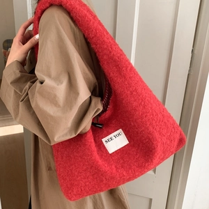 Détail du sac hobo en peluche rouge avec texture bouclée et étiquette SEE YOU