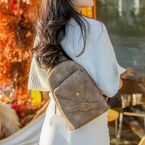 Foto exterior de un bolso bandolera vintage de cuero sintético marrón en un modelo