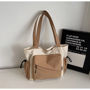 Macro view of large canvas tote bag showing side drawstring pocket and contrast stitching