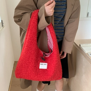 Détail du sac cabas en peluche rouge avec bouton corne et doublure à carreaux