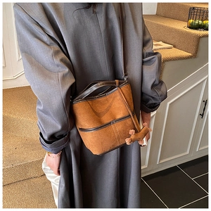 Brown suede bucket bag for women with leather trim and cute puppy charm on steps