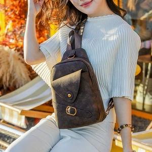 Detalle del bolso bandolera retro marrón oscuro con textura mate y hebilla metálica