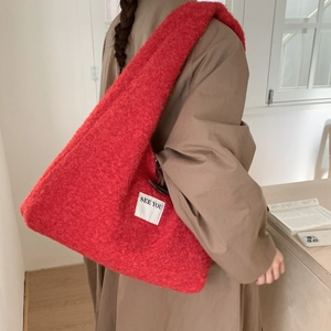 Gros plan sur la texture peluche rouge et l'étiquette SEE YOU sur le sac cabas doux
