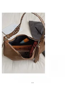 Detail view of large brown leather shoulder bag interior showing daily essentials storage