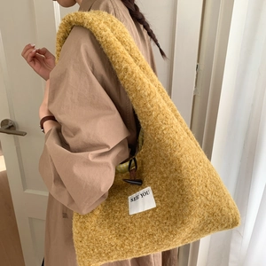 Détail du sac cabas en peluche jaune avec étiquette SEE YOU et bouton à bascule