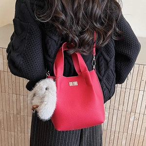 Pink bucket bag with litchi grain leather and a cute plush bunny charm detail
