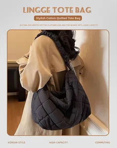 Detail view of black quilted puffer tote bag with wide pleated shoulder strap for winter
