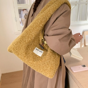 Détail du sac cabas en peluche gingembre avec fermeture à bascule et étiquette tissée