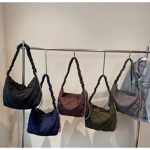 Row of quilted puffer tote bags in various colors showing soft diamond texture and zip detail