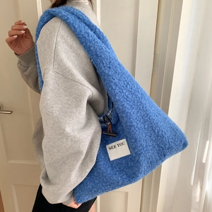 Détail du sac cabas bleu en peluche avec fermoir bûchette et doublure à carreaux