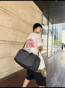Detail of gray travel bag with side zipper shoe compartment and durable strap