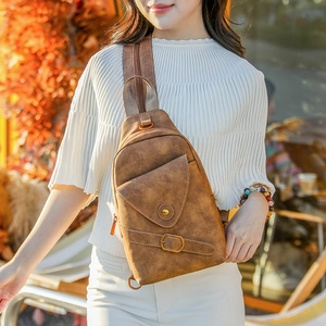 Detalle del bolso de pecho vintage marrón en cuero texturizado con hebilla metálica y solapa