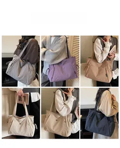 Detail view of large nylon tote bags in five colors featuring functional side drawstring pockets