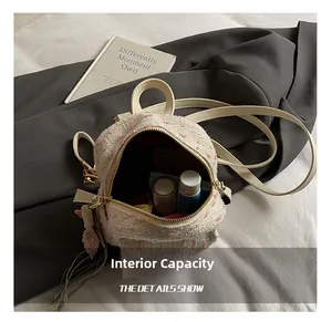 Detail of tweed mini backpack interior showing capacity for phone and cosmetics