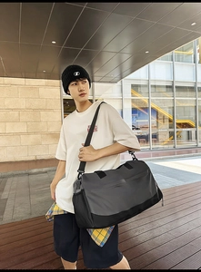 Outdoor lifestyle view of grey sports bag with side mesh pocket and adjustable strap
