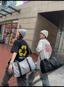 Street view shot showing large capacity waterproof gym bags in grey and black colors